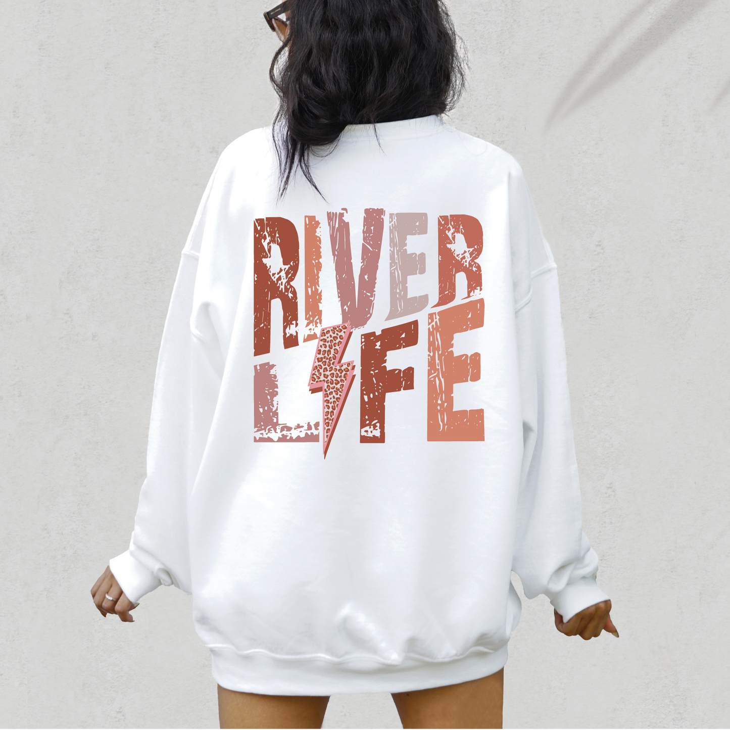 a woman wearing a white sweatshirt with the words river life printed on it