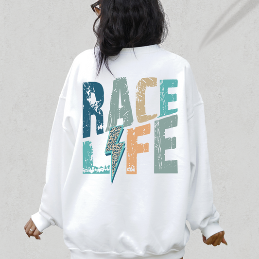 a woman wearing a white sweatshirt with the word race life printed on it