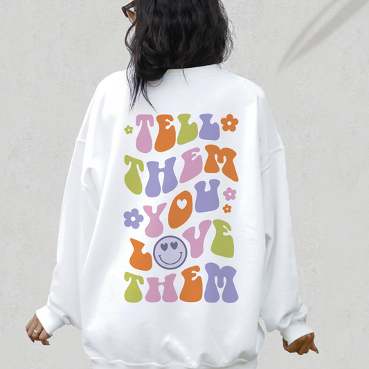 a woman wearing a white sweatshirt with colorful letters on it