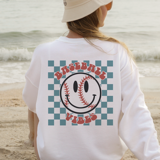 a woman sitting on a beach with a baseball on her back